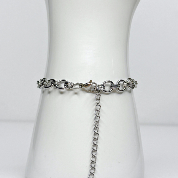 Silver chain belt on a mannequin with a plain background showing lobster clasp closure and extender chain of bracelet.
