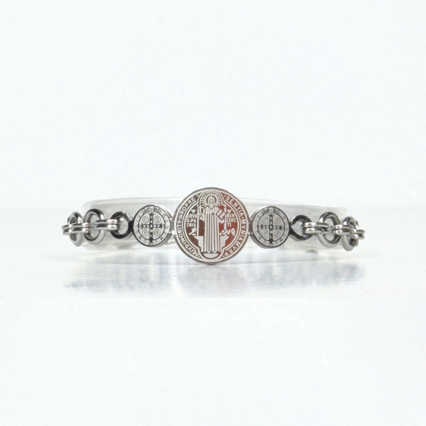 Stainless steel in Silver tone bracelet with circular designs on a white background. Saint Benedict is the design engraved.