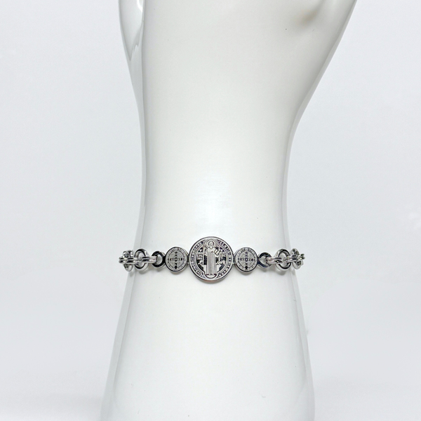 Silver bracelet with circular designs on a mannequin wrist against a white background